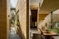 tan hallway with glass walls revealing garden views