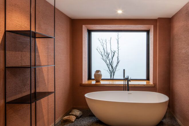 soaking tub in front of large window