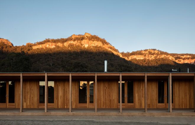 one-story wood building in front of mountains