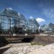 A series of four glass structures full of trees and plant life.