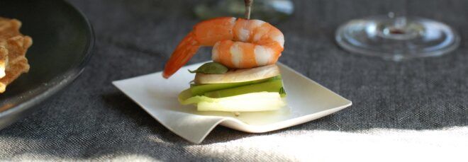 A shrimp appetizer on a small disposable plate.