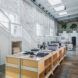 White walls lining a clothing facility with wood workbenches.