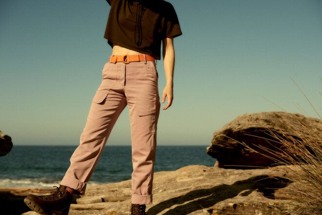 person wearing black T-shirt, mauve pants and orange utility belt