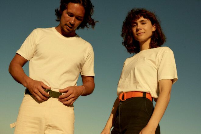 two people in black and white outfits wearing utility belts