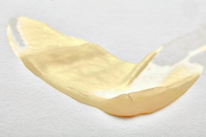 smeared beige eye cream on white background