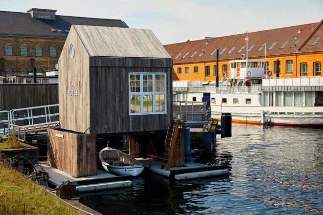 wooden tiny home floating on canal