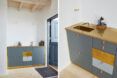 hotel kitchenette with small sink and gray cabinets