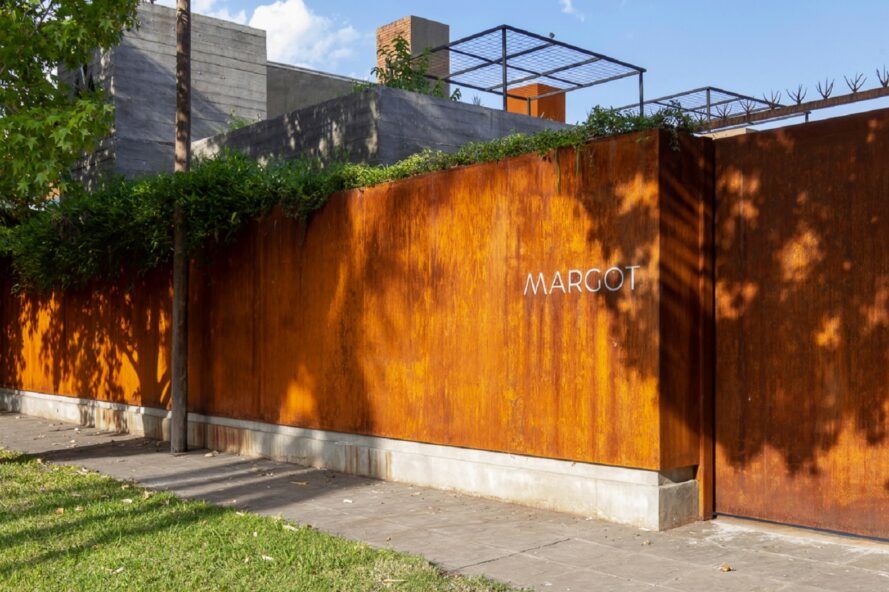 A one-story rectangular volume with letters reading "Margot." A green terrace is partially visible from the roof.
