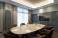 A meeting room with several chairs around an oval-shaped wood table.