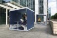 rendering of person working inside black and white office pod