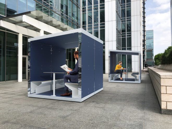 rendering of person working inside black and white office pod