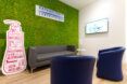 sofa and blue chairs in front of moss wall