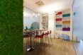 tall table with red chairs next to green wall