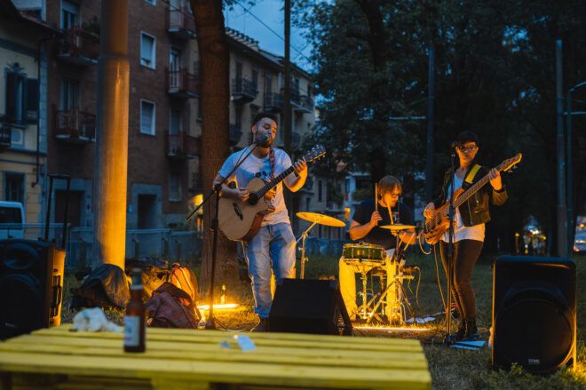band playing on small stage in a park at dusk