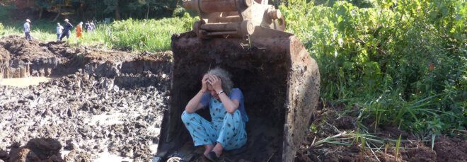 Joannah Stutchbury sitting on a piece of machinery equipment to stop digging at a site in Kenya.