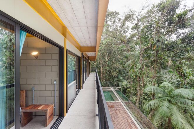 bedroom with glass wall open to a narrow balcony