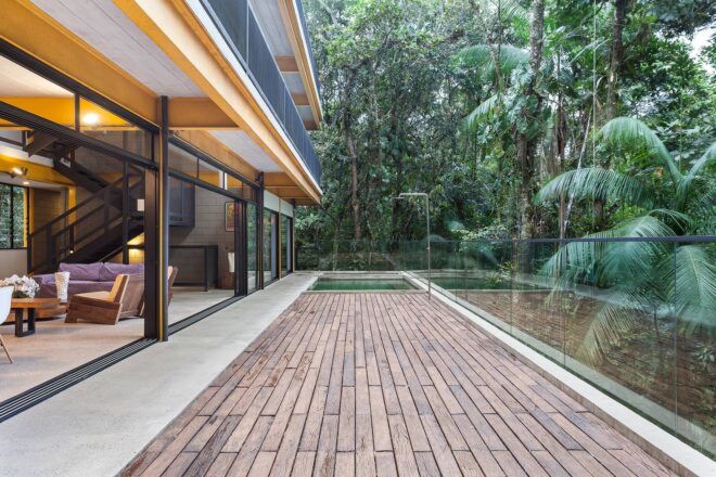 living room with glass wall open to wood patio