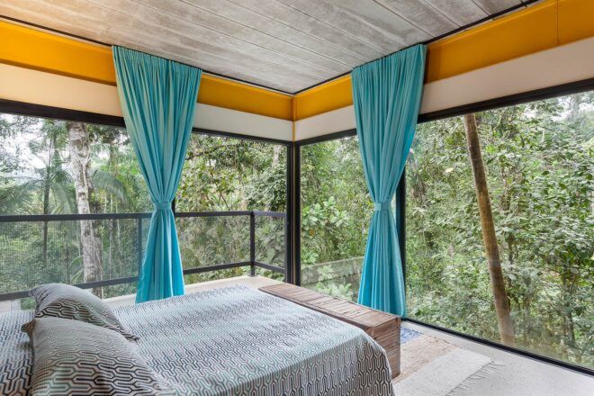 white bed facing walls of glass