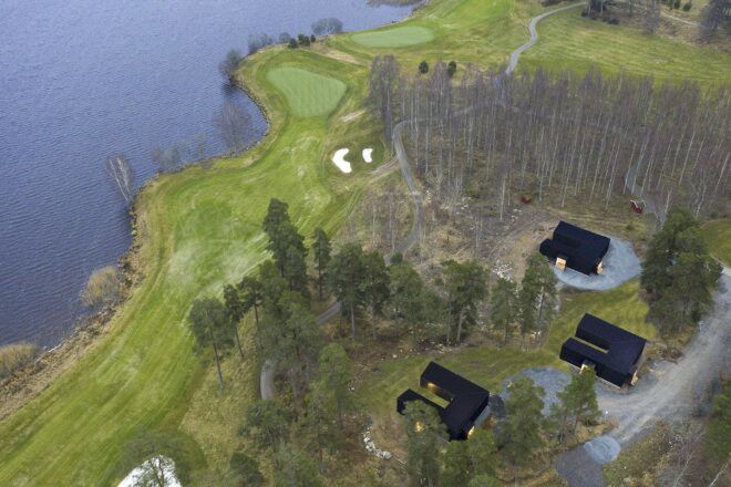 three black U-shaped cabins facing water