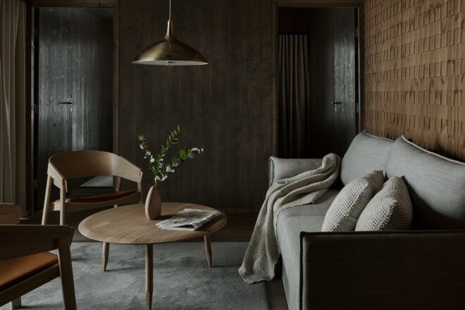 dark living room with beige sofa and wood round coffee table