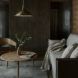 dark living room with beige sofa and wood round coffee table