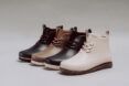 one white boot, two black boots, and one brown boot on white background