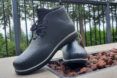 black rain boots on table with trees in distance