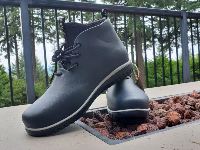 black rain boots on table with trees in distance