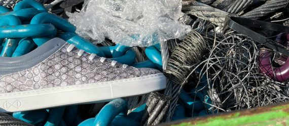 gray vegan shoe next to bubble wrap in a pile of trash