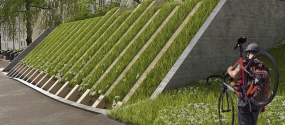 A person holding a bike and walking toward a bike parking area covered by a green roof.