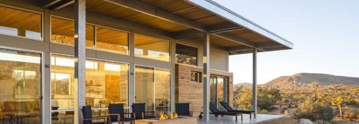 A covered patio connects to floor-to-ceiling windows.