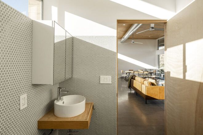 A bathroom with a white sink and white walls.