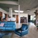A living room area with light-tone wood floors and a blue leather-like sofa and armchair.
