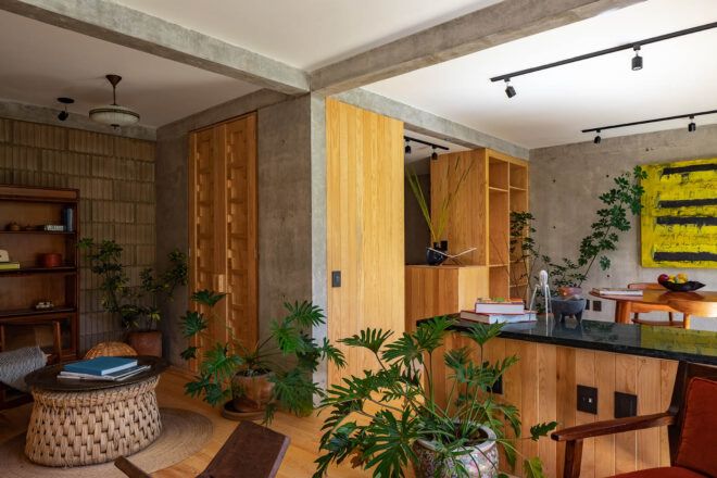 An alcove with a wooden bookshelf and reading nook connects to the living room.