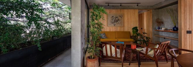 From left to right, a green terrace connects to a modern living room with wood accents.