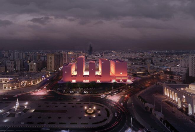 An aerial photo of five connected orange structures at dusk.