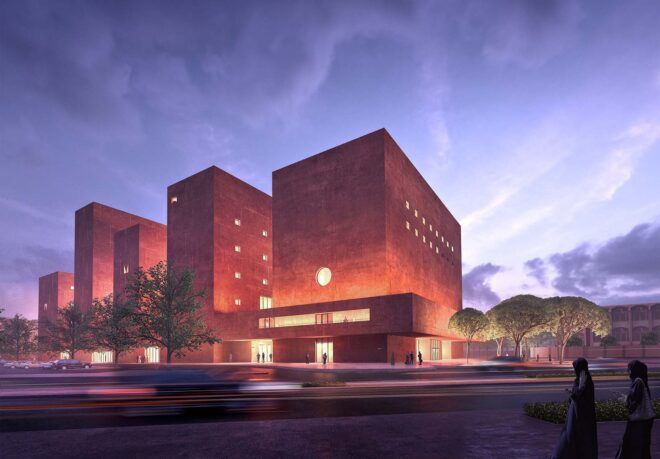 A streetview of a series of orange buildings lit up at night.