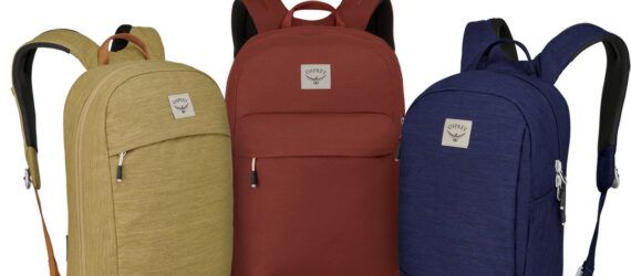 Three backpacks in tan, red and blue.