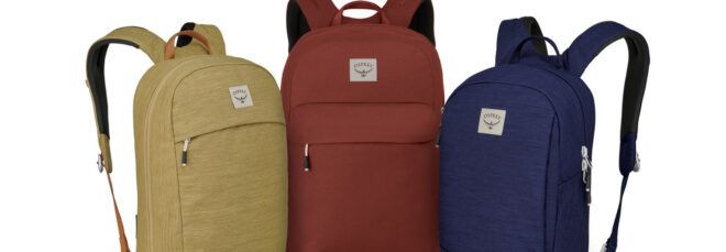 Three backpacks in tan, red and blue.