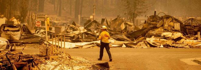 A firefighter surveying a burned city.