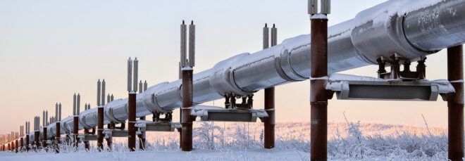 A pipeline going through a wintry Alaskan landscape.