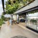Large sliding glass doors that open onto a bright patio surrounded by greenery.