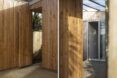 To the left, a wood entryway. To the right, a wood hallway looking into a room with an open doorway.