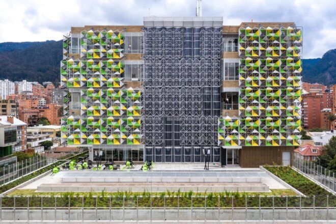 The back of the building, showing the green and yellow facade broken up in the middle with steel.