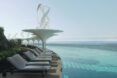 The side of a floating hotel, showing a deck of pool chairs looking out on the ocean.