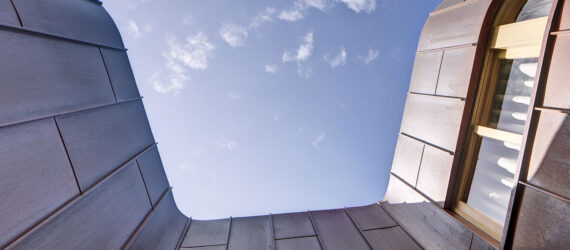 A view of the top of the building framing the sky.