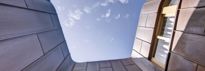 A view of the top of the building framing the sky.