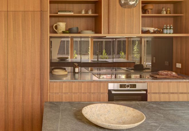 A kitchen with wood cabinets and slate countertops.