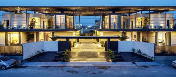 A streetview of the home as the sun goes down, showing lights within.