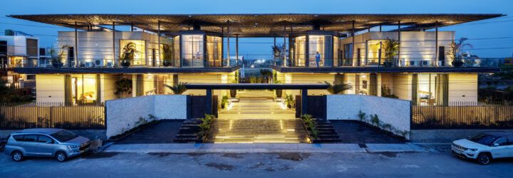 A streetview of the home as the sun goes down, showing lights within.